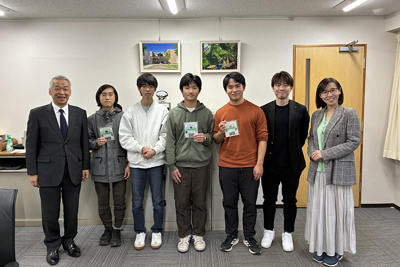 修了証を手に、社会人コーチの皆さんを交えた校長室での記念撮影