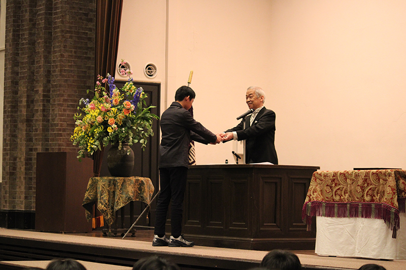 武蔵バッヂを新入生に渡す様子