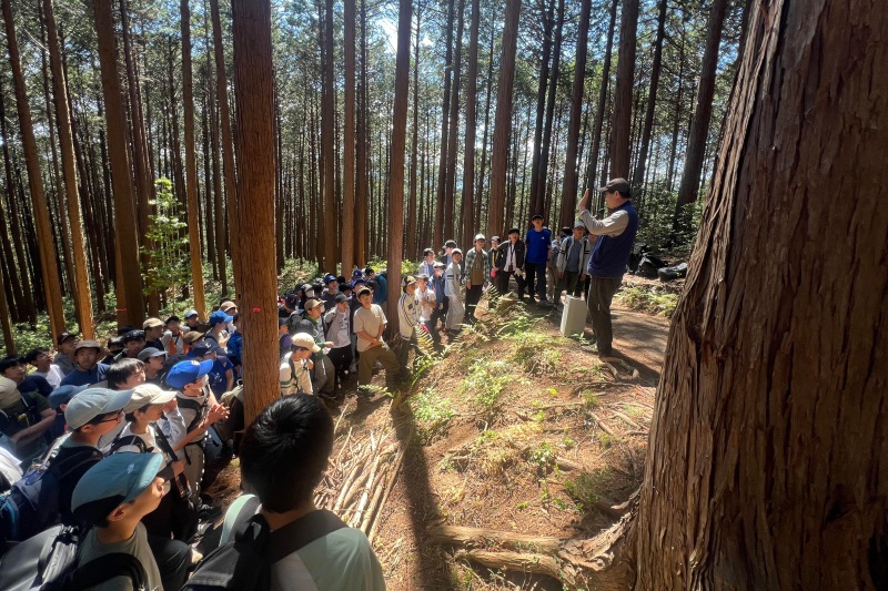 学校山林で大場氏のレクチャーを受ける生徒たち